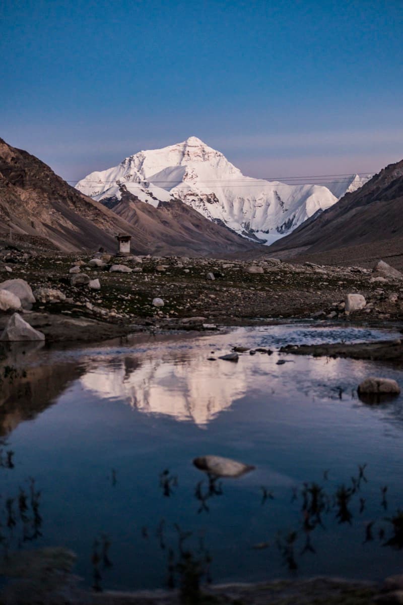Mount Everest north face reflected in a still alpine pond at twilight
