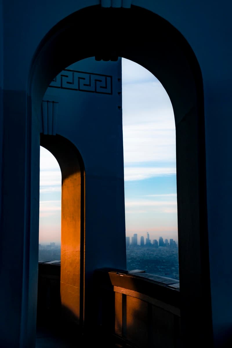 Los Angeles skyline seen through Art Deco arches at Griffith Observatory at sunrise