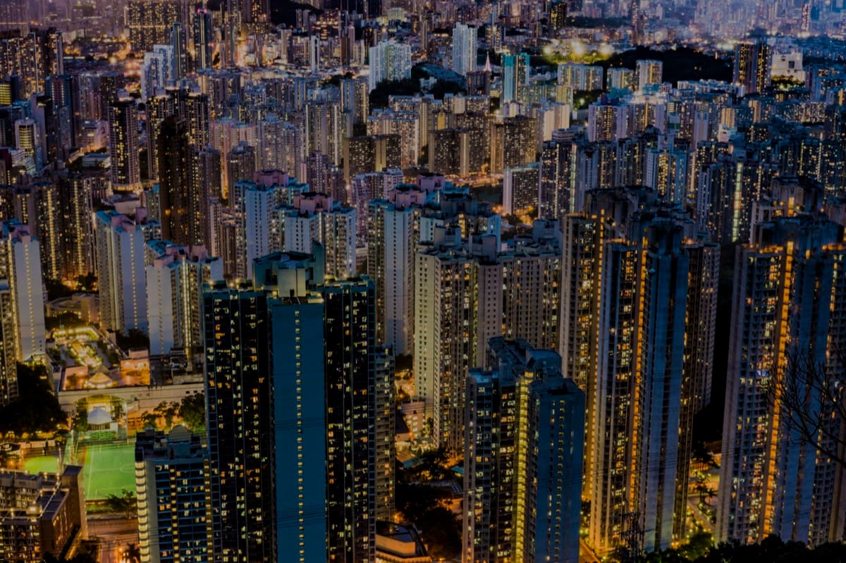 Aerial nighttime view of densely packed Kowloon high-rise residential towers