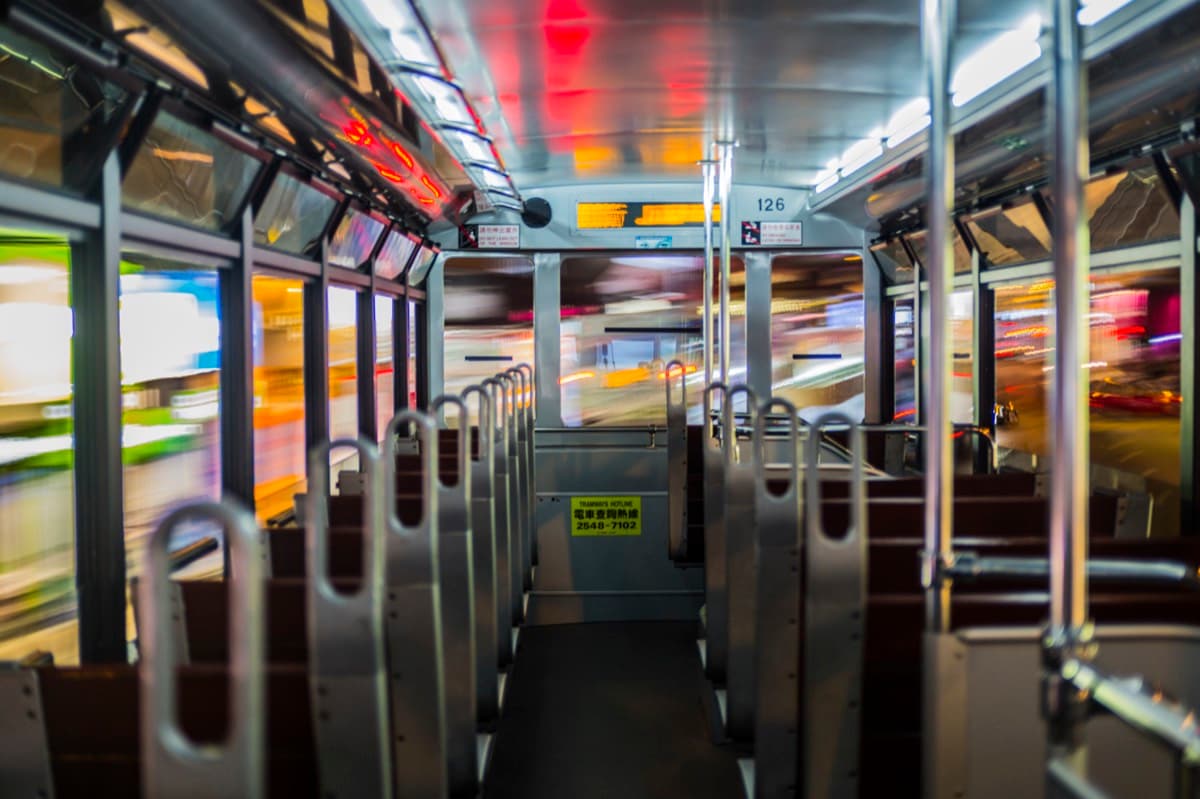 Hong Kong tram rear stairwell at night with motion blur and route number visible